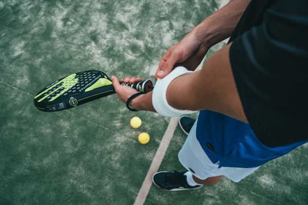 Tennisspieler mit Tennisschläger und Armbinde.